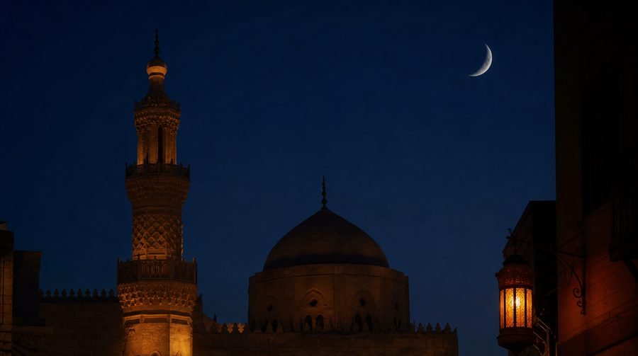 Historic Cairo minaret under a crescent moon at night